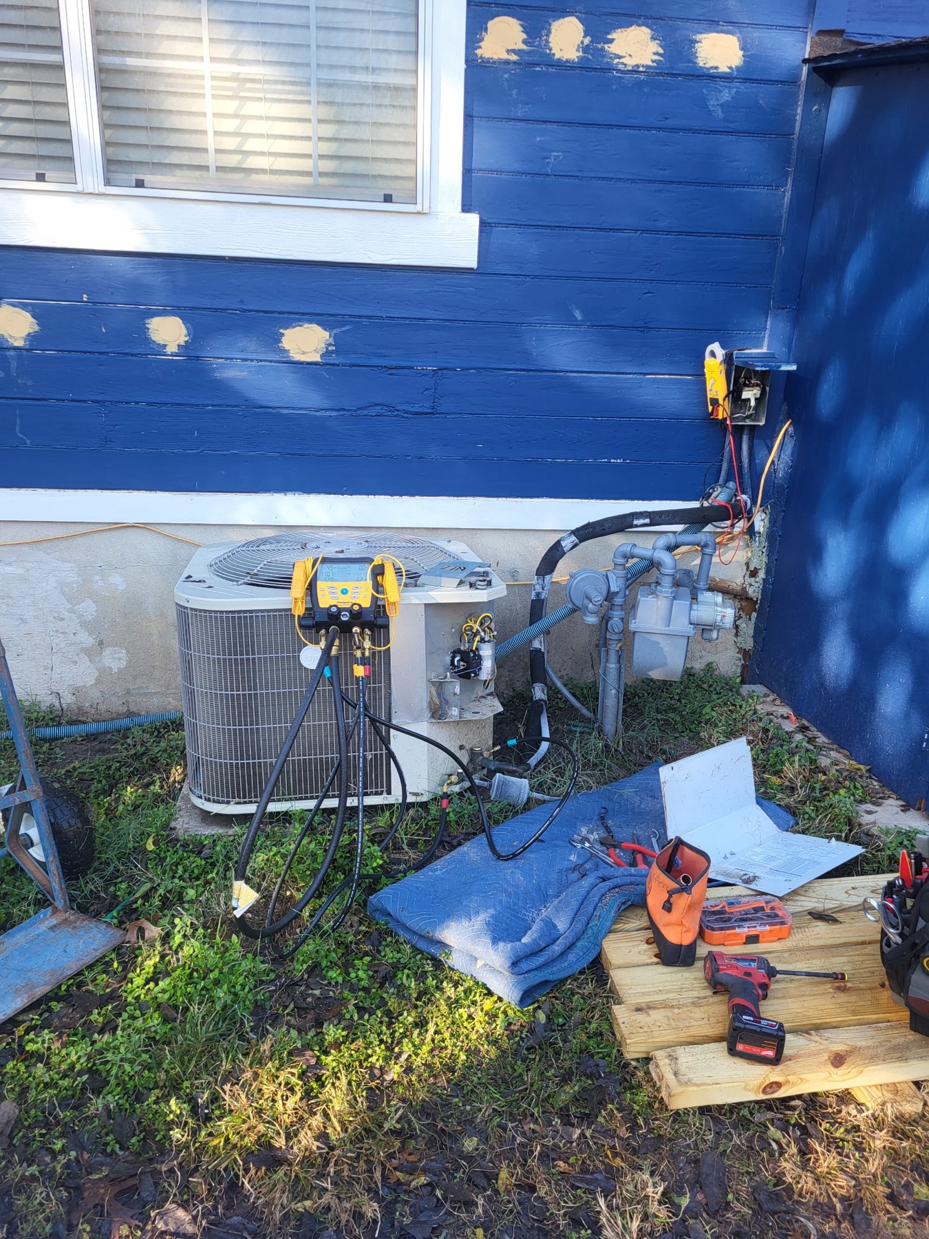 EZ Heating and Cooling gauges connected to an air conditioner during a repair diagnosis