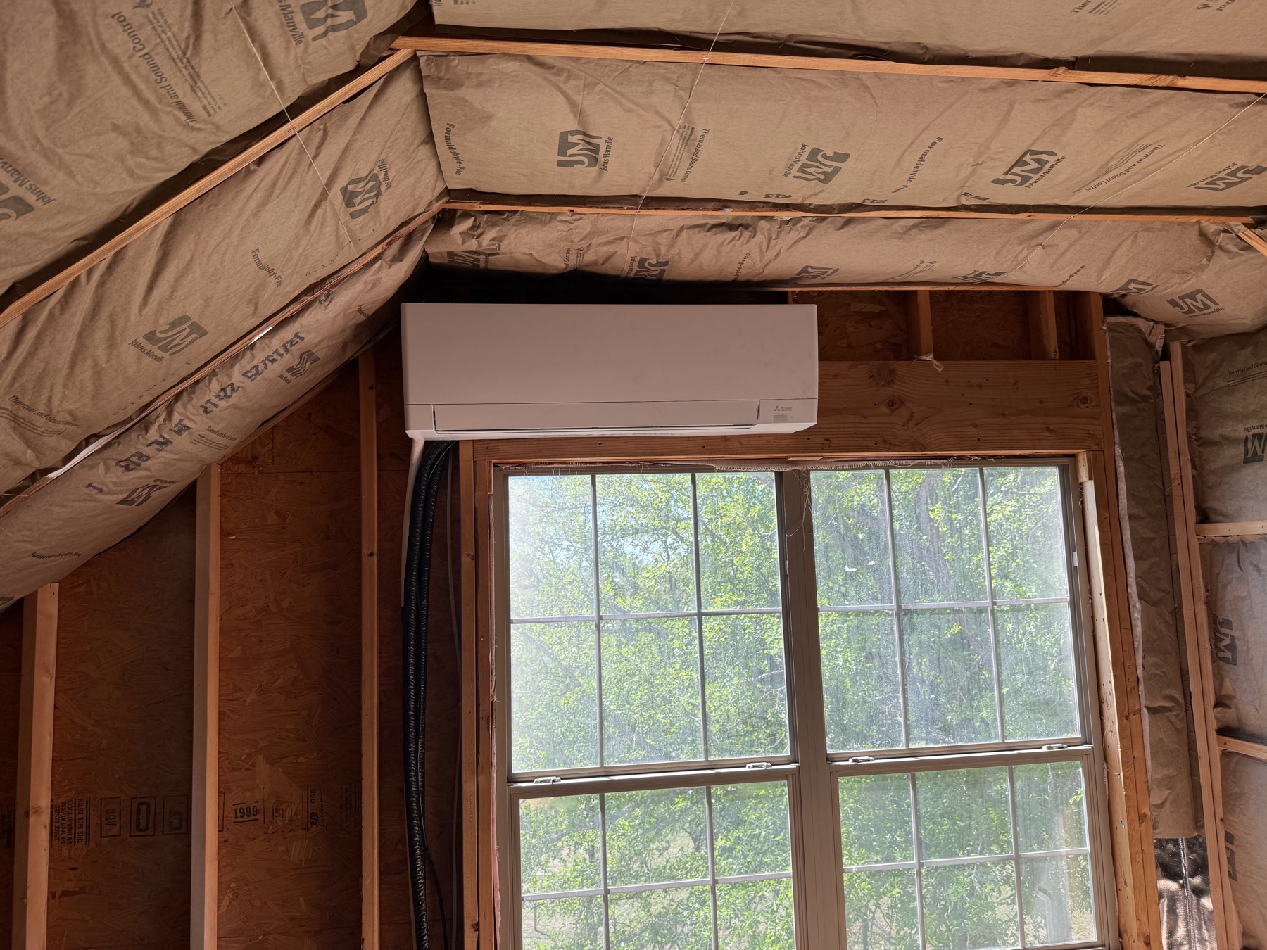 Mini split head installed in a room under construction with new framing