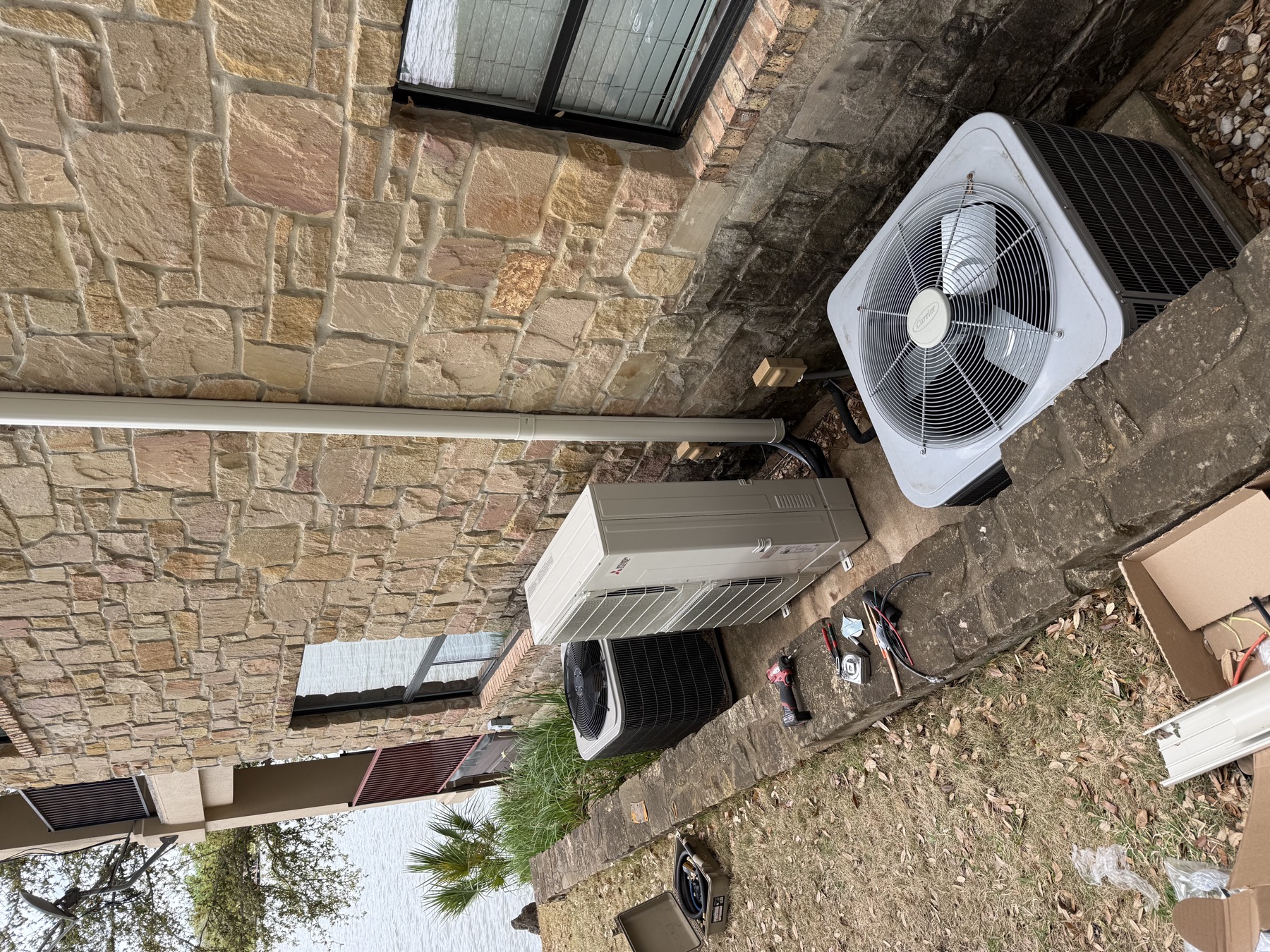 Mini split and package unit installed at a stone lakeside home by EZ Heating and Cooling