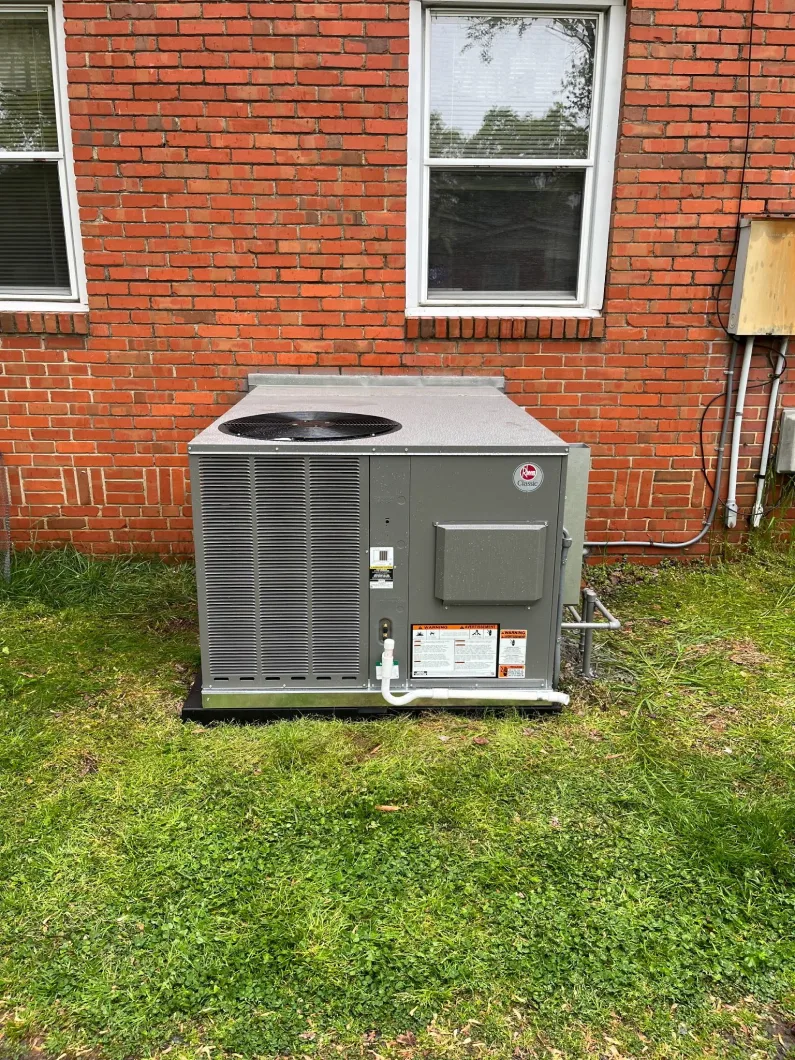 Rheem package unit installed beside a brick home by EZ Heating and Cooling