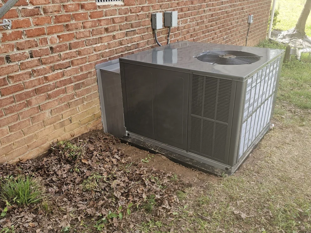 Package unit installed beside an older brick home by EZ Heating and Cooling