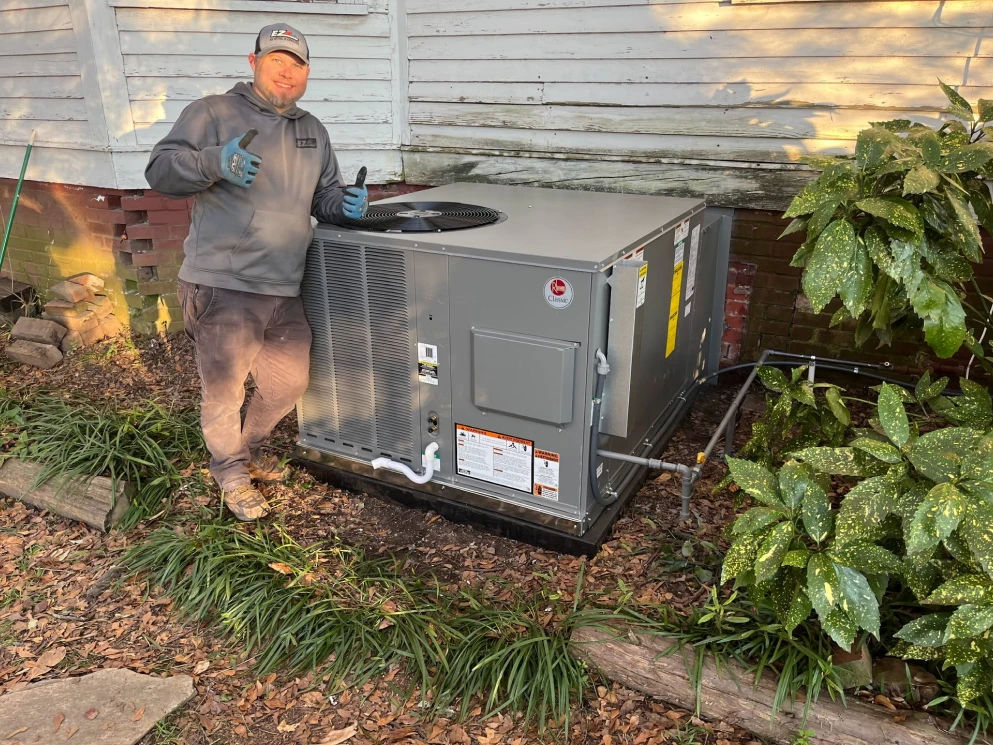 EZ Heating and Cooling technician with a newly set package unit at a Mint Hill area home