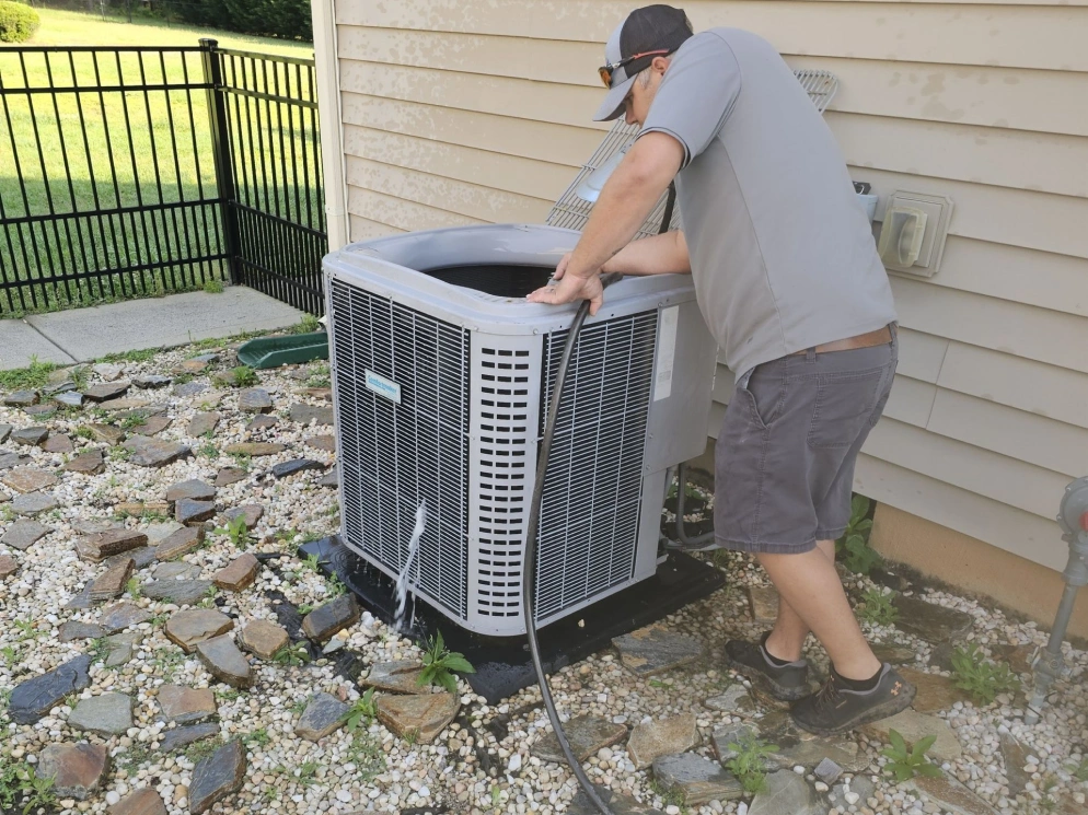 EZ Heating and Cooling technician servicing a condenser at a Charlotte area home