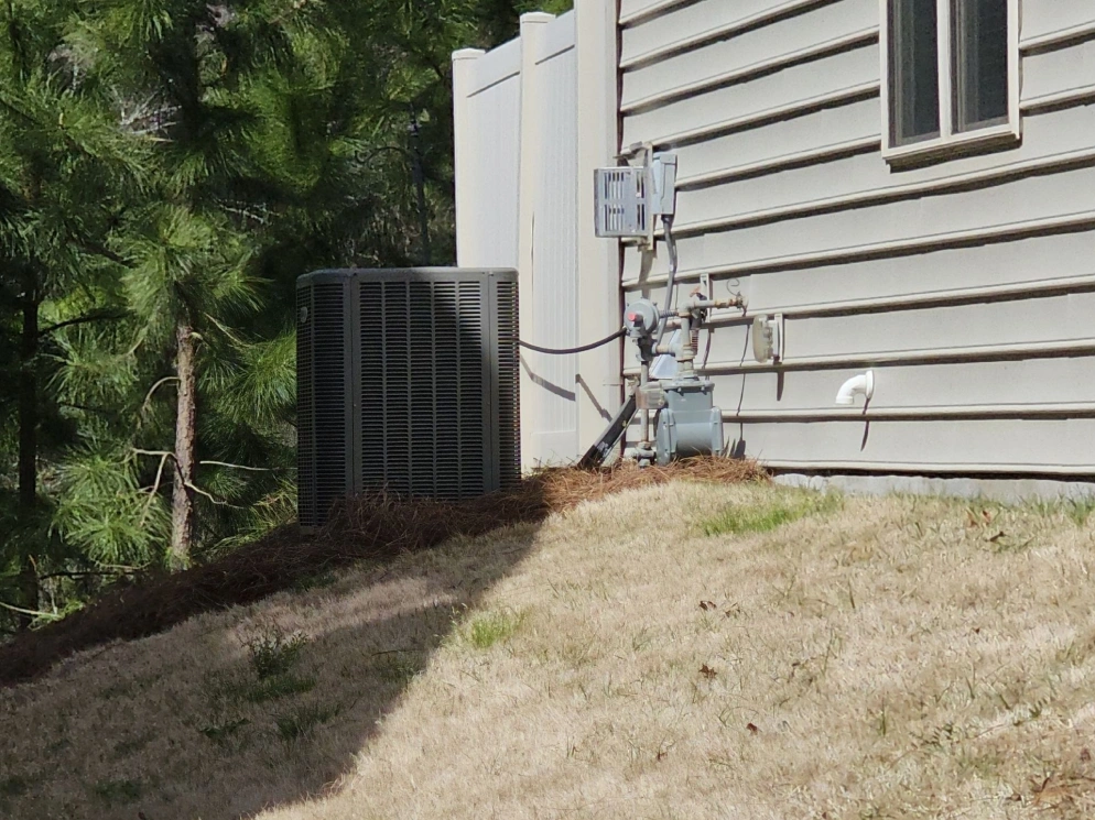 Condenser installed on a hillside at a Mount Holly area home by EZ Heating and Cooling