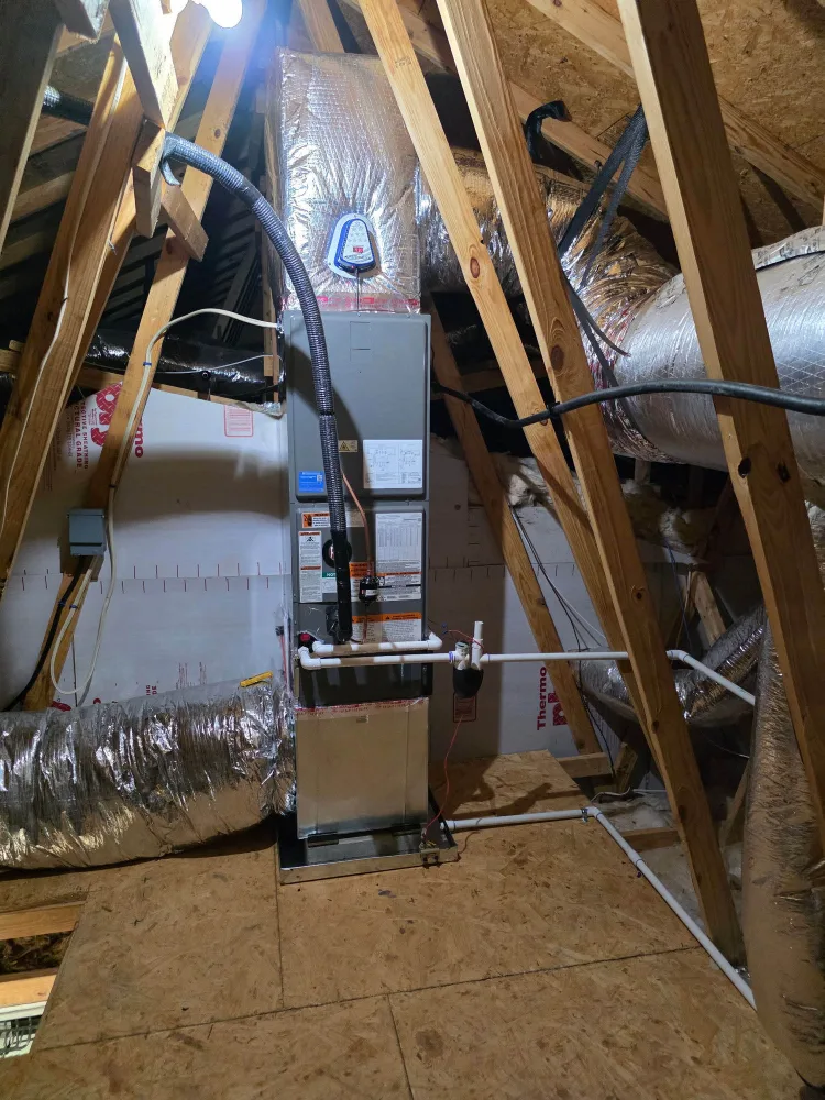 New attic air handler standing upright on its platform with an insulated supply plenum and sealed flex duct runs
